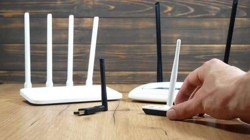 Wireless Routers and Network Adapters on Wooden Surface