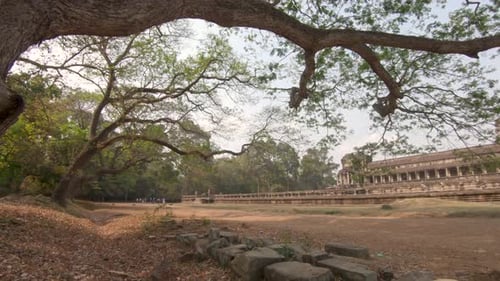 Wide pan shot showing the large temple buildings in Angkor Wat in Cambodia, bright sunny daylight.