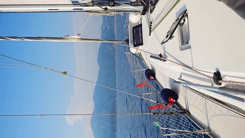 Yacht Sailing in an Open Sea Closeup View of the Deck Mast and Sails Clear Sky Waves and Water