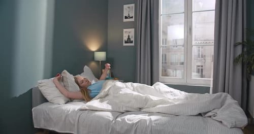 Woman Wakes Up and Stretches in Bed