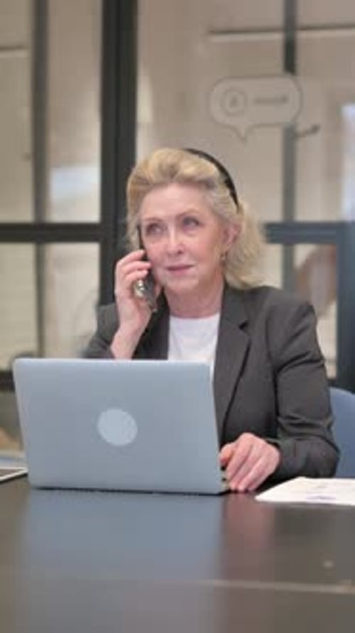 Businesswoman on Phone at Desk in Modern Office