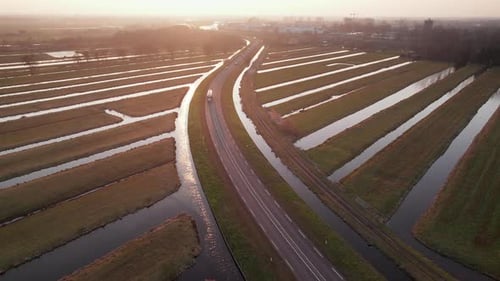 Country Road Through Beyersche Vliet Canals And Dutch Polders At Sunset In Gouderak, Netherlands. wi