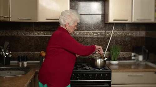 Senior Woman Cooking at Stove in Kitchen