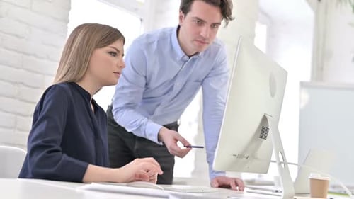 Man and Woman Working Together at Computer
