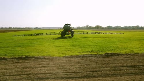 Tractor Sprayer Irrigates the Field Application of Fertilizers and Pesticides Aerial View