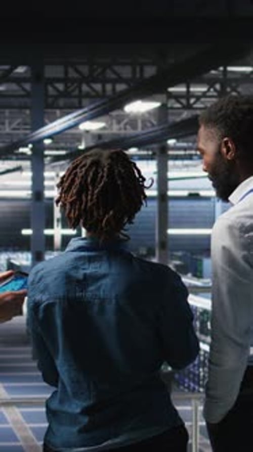Vertical Video Data Center Manager Talking with Workers Doing Maintenance on AI Supercomputers