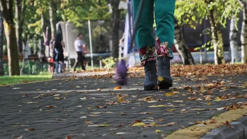 Un concierge balaie les feuilles jaunes tombées dans le parc