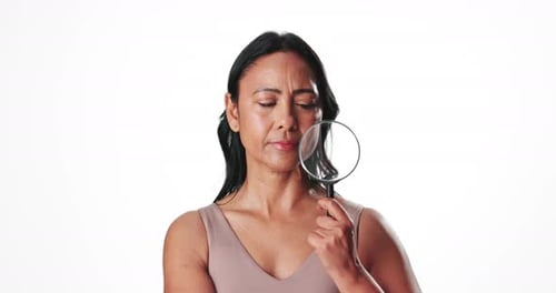 Woman, check and magnifying glass for skincare in studio for inspection, skin analysis and beauty