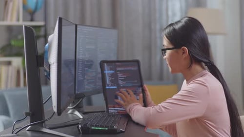 Une programmeuse adolescente regarde une base de données sur une tablette tout en créant une application de développement d'une Appli d'ingénieur logiciel