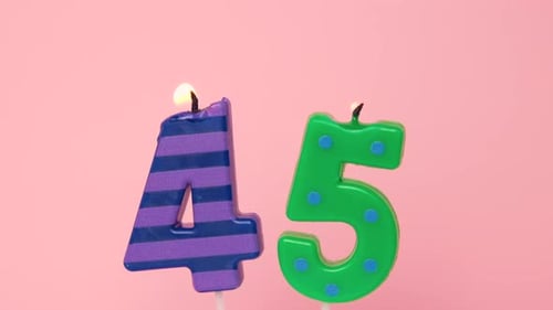 Forty Five Years Anniversary Video Banner with Burning Spotted Green and Striped Purple Candles