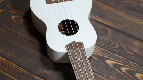 White Ukulele on Rustic Wooden Surface