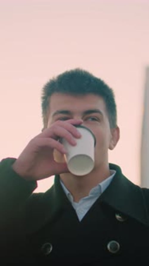 Young Adult Man Drinks Coffee Outdoors in City