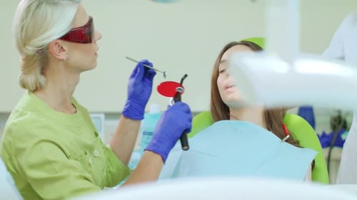 Dentist Working on Teen Patient's Teeth in Clinic