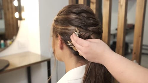 Stylist Attaching Hair Decoration Accessories to a Bride Hair While Doing Her Wedding Hairstyle