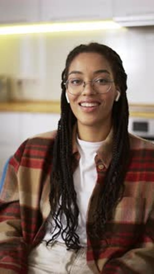 Young Woman Smiling Indoors Wearing Plaid Shirt