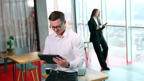 Man Uses Tablet in Bright Modern Office