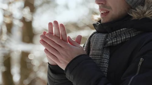 Caucasian Man Rubs and Warms His Bare Hands in Frosty Winter Weather