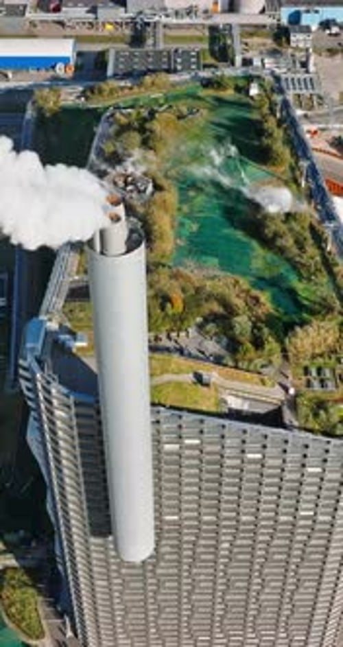 Aerial drone view of CopenHill artificial ski slope on the roof of an energy plant. Vertical
