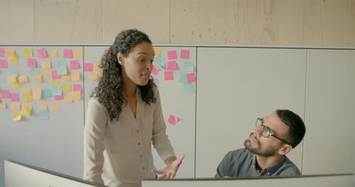 Two Business People Working in Office on Computer and using Adhesive Notes