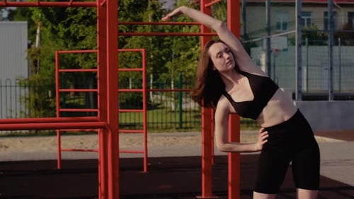 Young Woman Stretching at an Outdoor Fitness Park