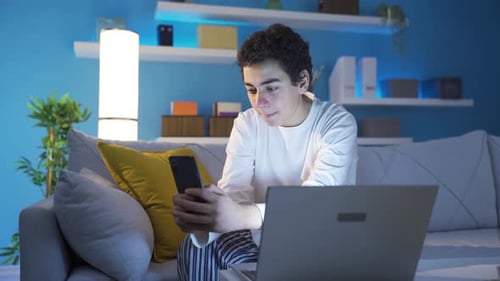 Teen Using Phone and Laptop on Couch