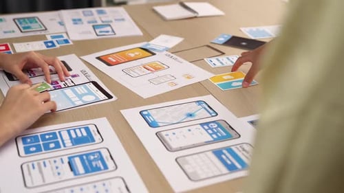 Team Collaborates on Mobile App Design at Table