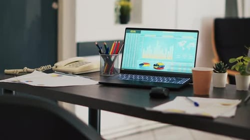 Laptop Shows Financial Data in Modern Office Setting