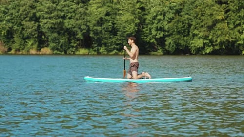 On Lake Young Attractive Happy Man Paddle on Their Knees Rowing Surfboard Sport Surfer Water Travel
