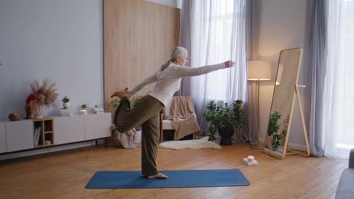 Senior Woman Doing Yoga Balance Pose in Home
