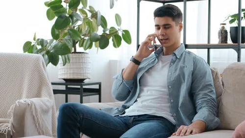 Man Relaxing on Sofa Talking on Phone