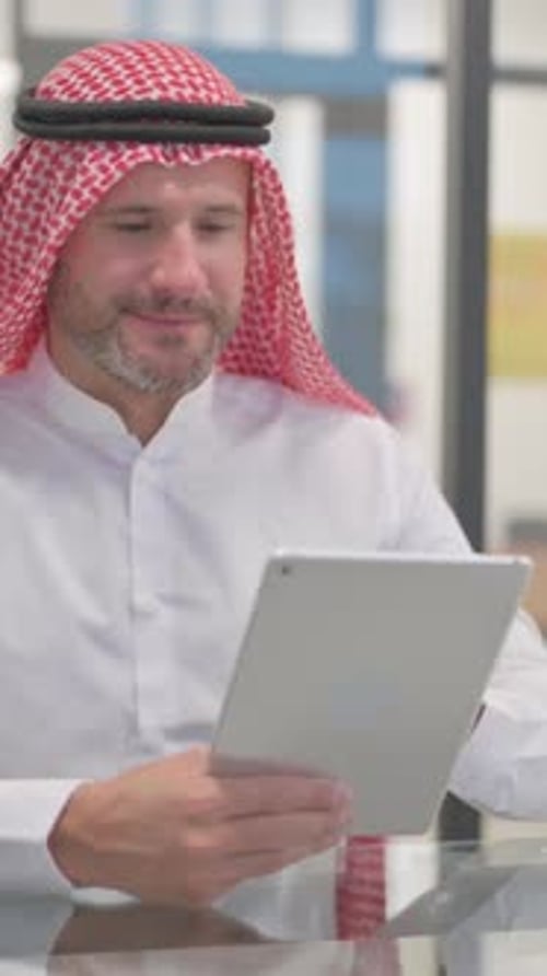 Arab Man using Digital Tablet in Office, vertical video