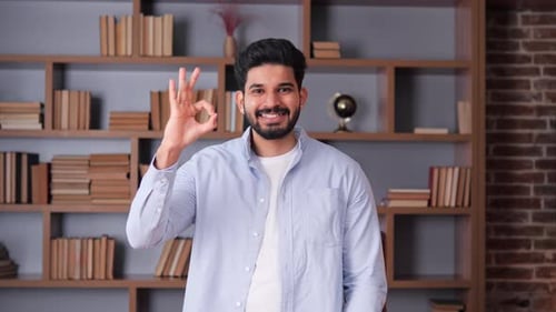 Bonito, sábio, alegre, indiano gesticulando bem, sinal em um escritório