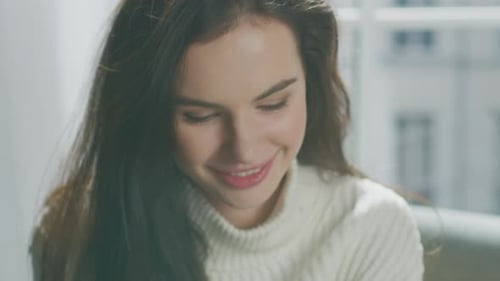 Attractive young woman smiles at the camera indoors