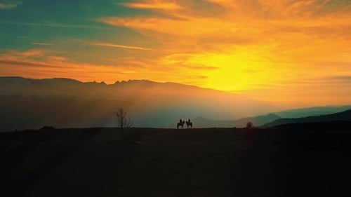 Zwei Menschen reiten auf Pferden bei einem wunderschönen Sonnenuntergang