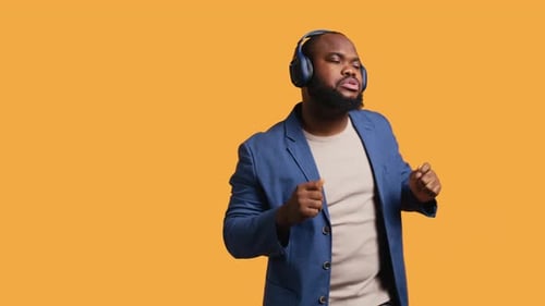 Man Having Fun Dancing on Rhythm Listening to Headphones Studio Background