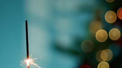 Festive Sparkler Burning with Bokeh Lights Background