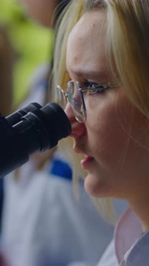 Female Scientist Looking Through Microscope in Laboratory