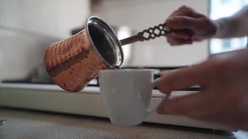 Pouring Hot Coffee into a Mug at Home