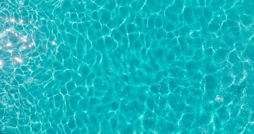 Blue Water in the Swimming Pool with Light Reflections