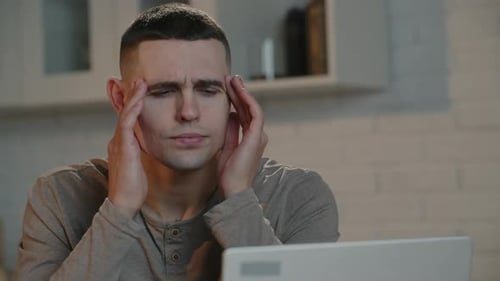 Man Frustrated While Working at Laptop