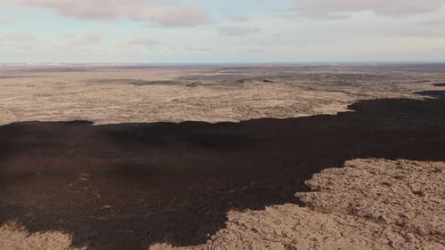 Barren inhospitable volcanic rock landscape, endless empty plain.