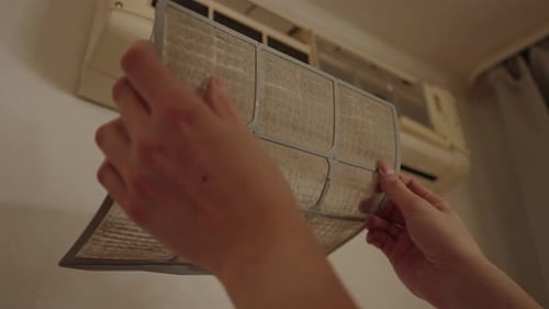 Hands Hold Up Dirty Air Conditioner Filter