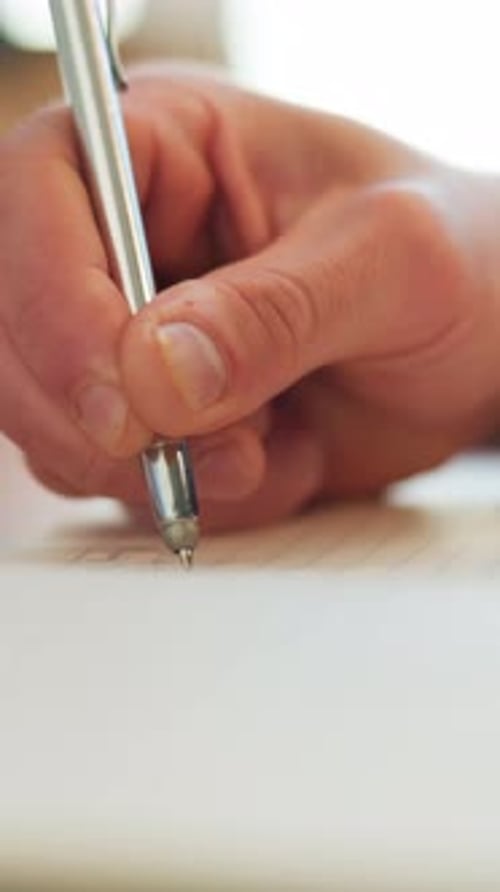 Hand Writes with Pen on Lined Paper