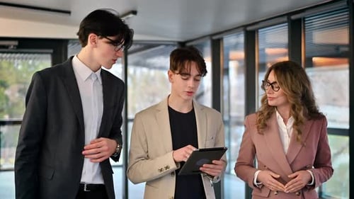 Business meeting in an office, female team leader and two young workers discussing business affairs