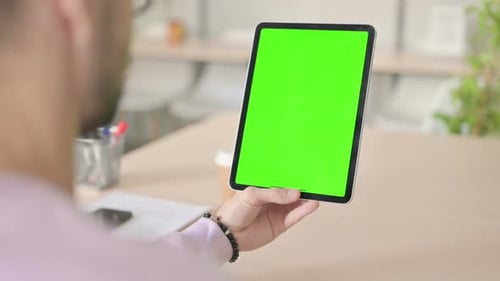 Rear View of Man Using Tablet with Green Chroma Screen