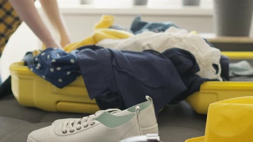 Young Adult Packing a Suitcase For Travel