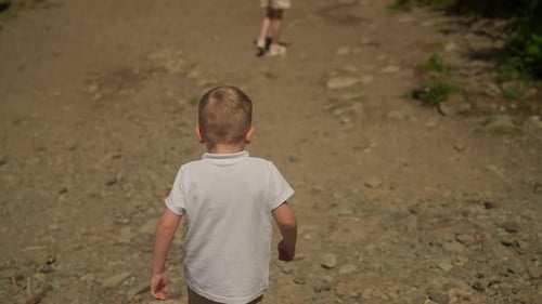 Preschooler Boy and Schoolgirl Walk Along Sandy Sea Shore