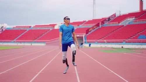 Asian para-athlete with prosthetic blades warms up body in the stadium.