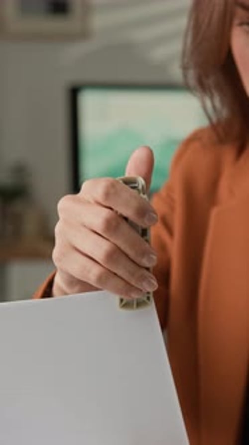 Businesswoman Using Stapler at Office Desk