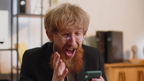 Man Reacts to Phone in Office Setting